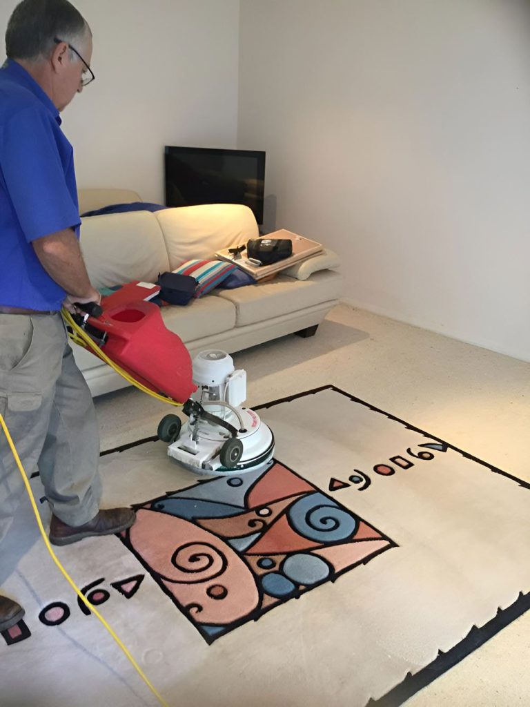 Man Cleaning The White Carpet — Dryology Carpet Cleaning in Cessnock, NSW