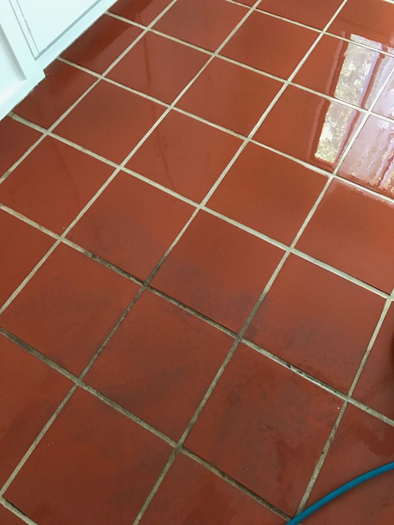 A Person Wearing Gloves is Cleaning a Tile Floor With a Sponge — Dryology Carpet Cleaning in Salamander Bay, NSW